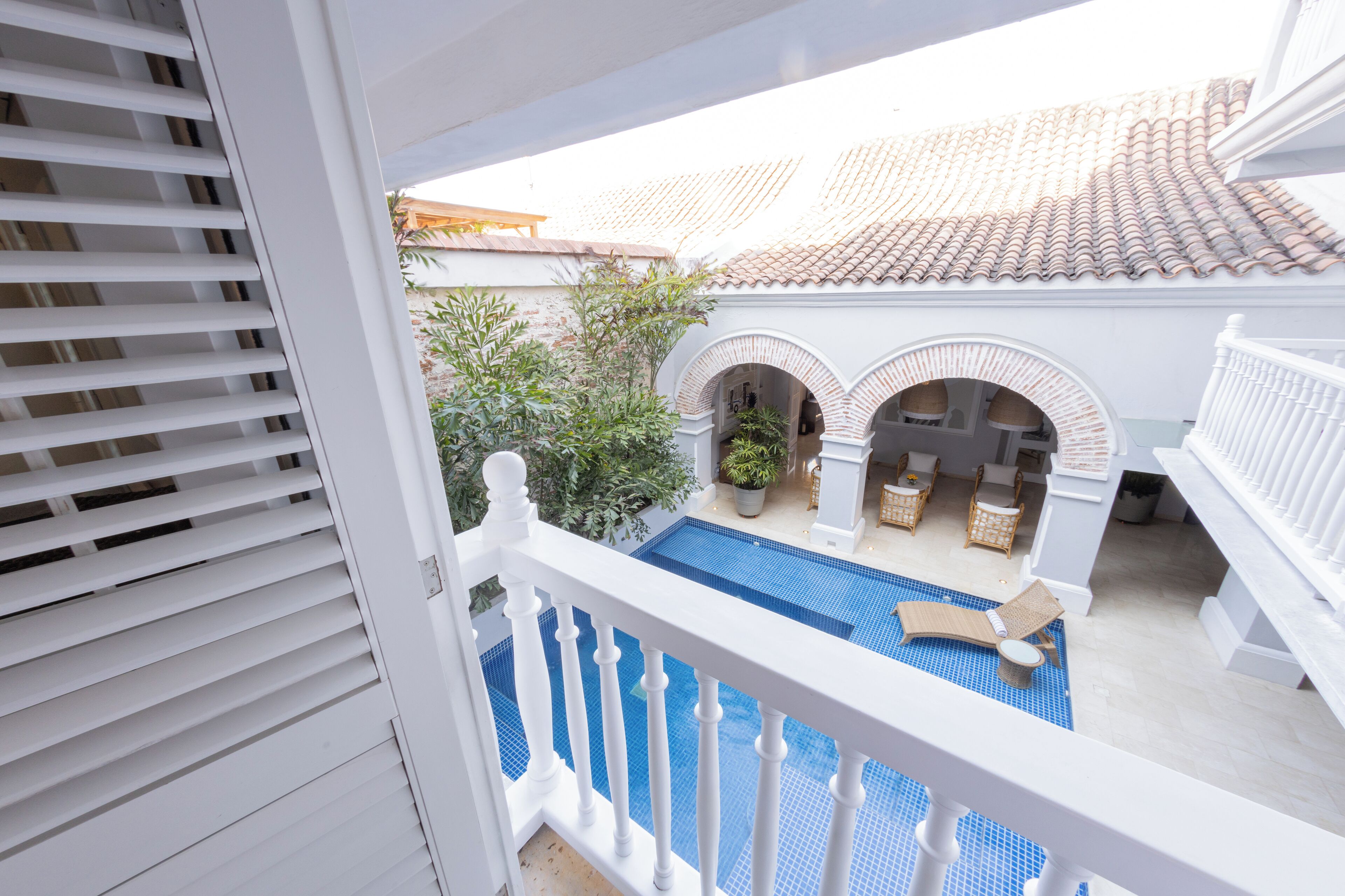 Un balcó amb piscina, barana blanca i teulada a la part posterior.