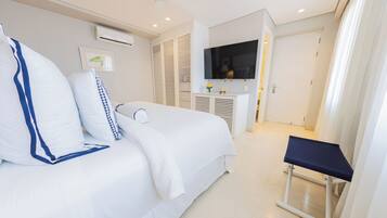 A hotel room with a bed, a bedside table, a TV, and a ceiling fan.