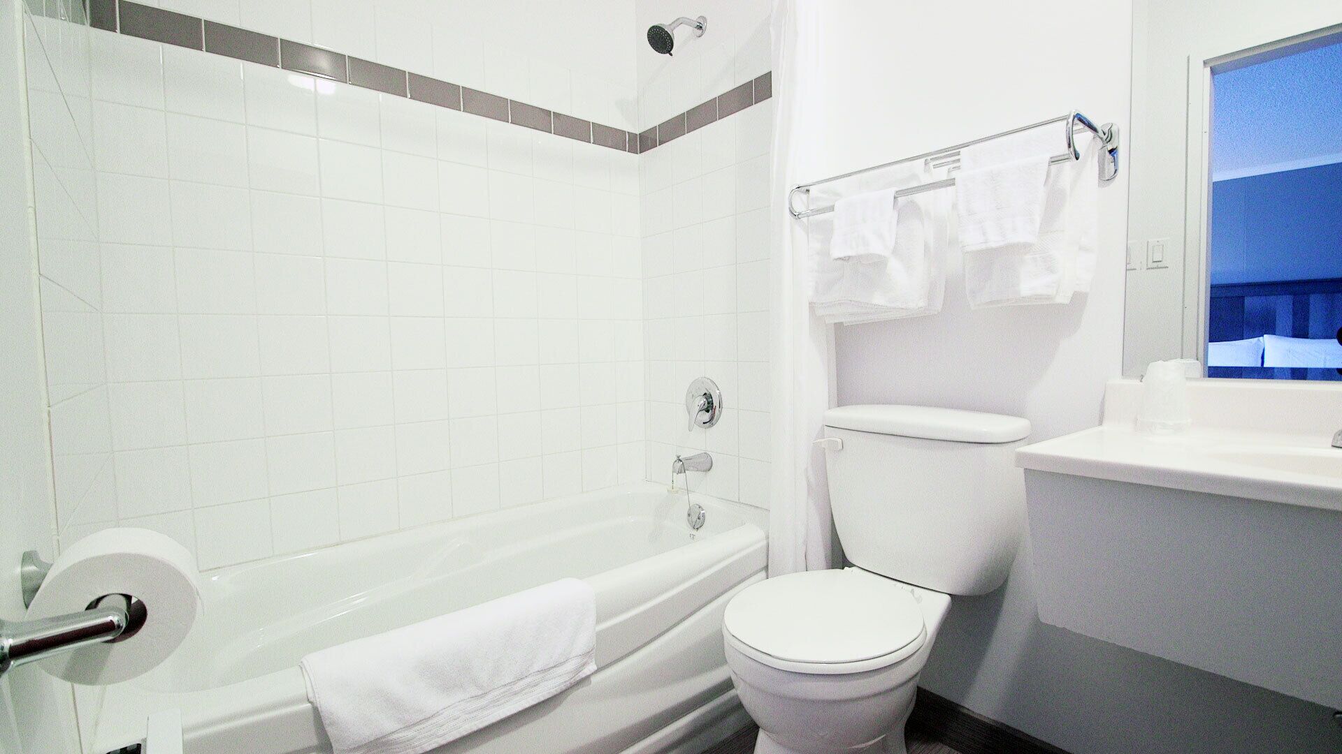 A bathroom with a bathtub, toilet, and a window.