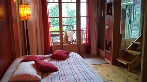 A bedroom with a bed, pillows, a window, and a staircase. - Baubaus House_Holidays house in Cuirone (Vergiate)