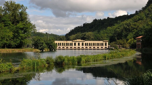 A riverside building with arched windows and a central courtyard. - Baubaus House_Holidays house in Cuirone (Vergiate)