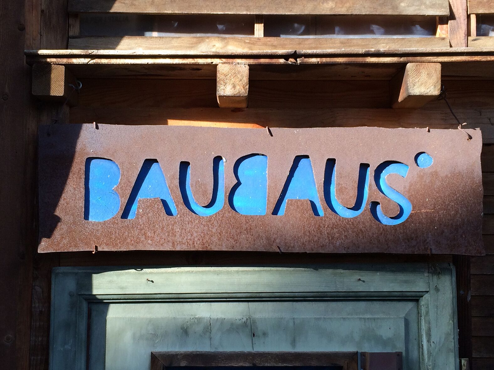 Une enseigne avec le mot « BAUHAUS » écrit en lettres bleues sur un fond marron.