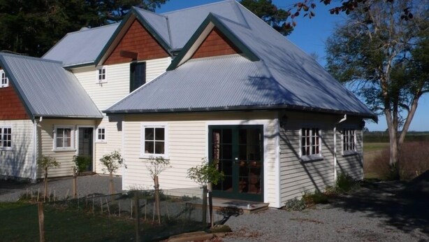 A two-story house with a gabled roof, a front porch, and a fenced yard. - The Stablehand Quarters at Gunyah Country Estate by Mt Hutt (Methven (Mt Hutt))