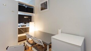 A compact room with a kitchenette, a dining area, and a small refrigerator. - Small Cozy studio with WiFi & cable (Southampton)