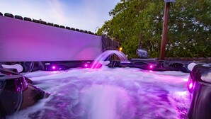A hot tub area with a water feature and purple lighting. - A Barn at the Quarry (Fredericksburg)
