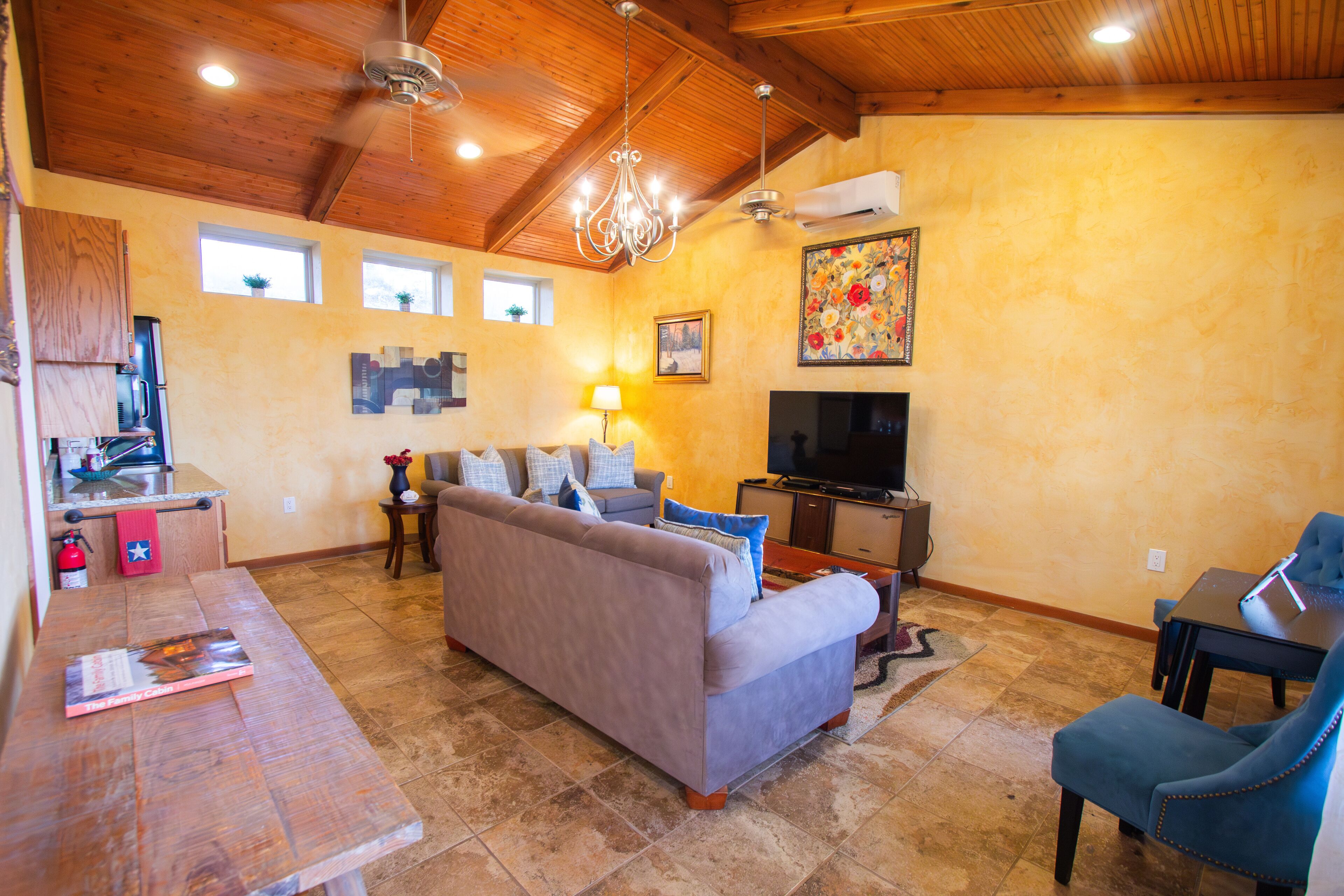 A living room with a sofa, a coffee table, a TV, and a fireplace.