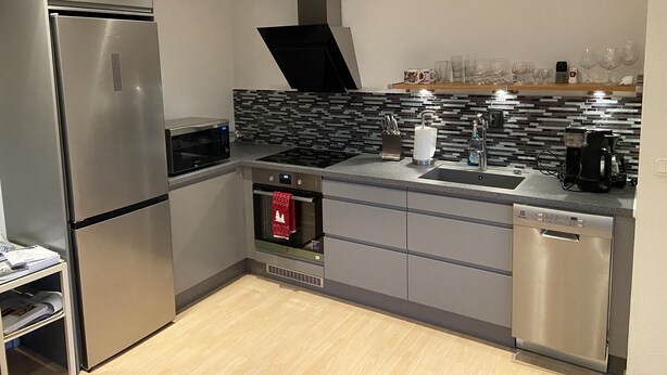 A modern kitchen with stainless steel appliances, a tiled backsplash, and a dishwasher. - Guesthouse built on the owner's plot. close to beach, shop and golf course. (Trelleborg)