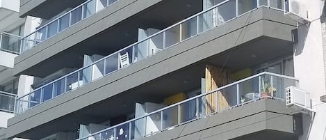 A multi-story building with balconies, large windows, and a modern architectural design.