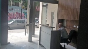 A reception area with a counter, a door leading outside, and a wall with a mural. - Palermo Market Luxury apartaments (Buenos Aires)