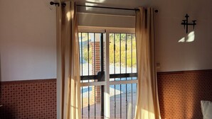 A room with a glass door leading outside, a patterned wall, a leather sofa, and a tiled floor. - Beautiful spacious villa with fantastic views and private pool (Alcaucin)