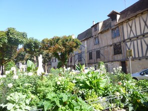 Um edifício tradicional em enxaimel com um jardim em primeiro plano.
