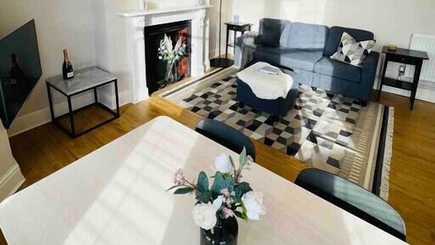 Una sala de estar moderna con chimenea, un sofá, una mesa de centro y un comedor.
