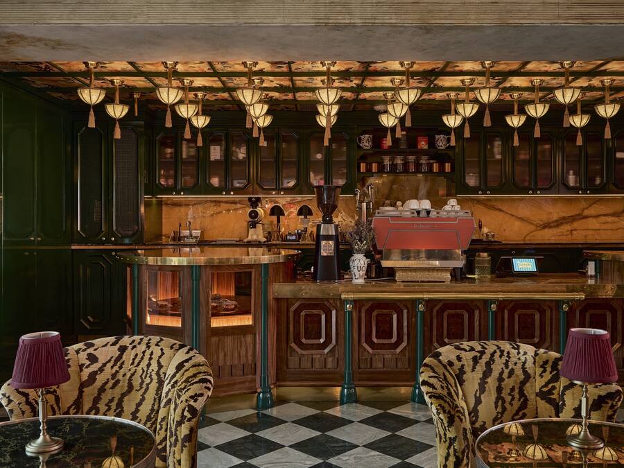 Un espace bar avec des chaises à motifs, un sol à carreaux et des lampes suspendues.