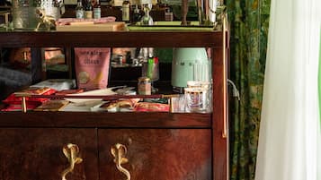 Uma área de bar com um armário de madeira, garrafas e um espelho.