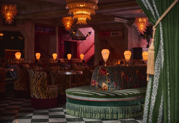 A restaurant with checkered flooring, patterned sofas, and hanging chandeliers. - Lafayette Hotel & Club (San Diego)