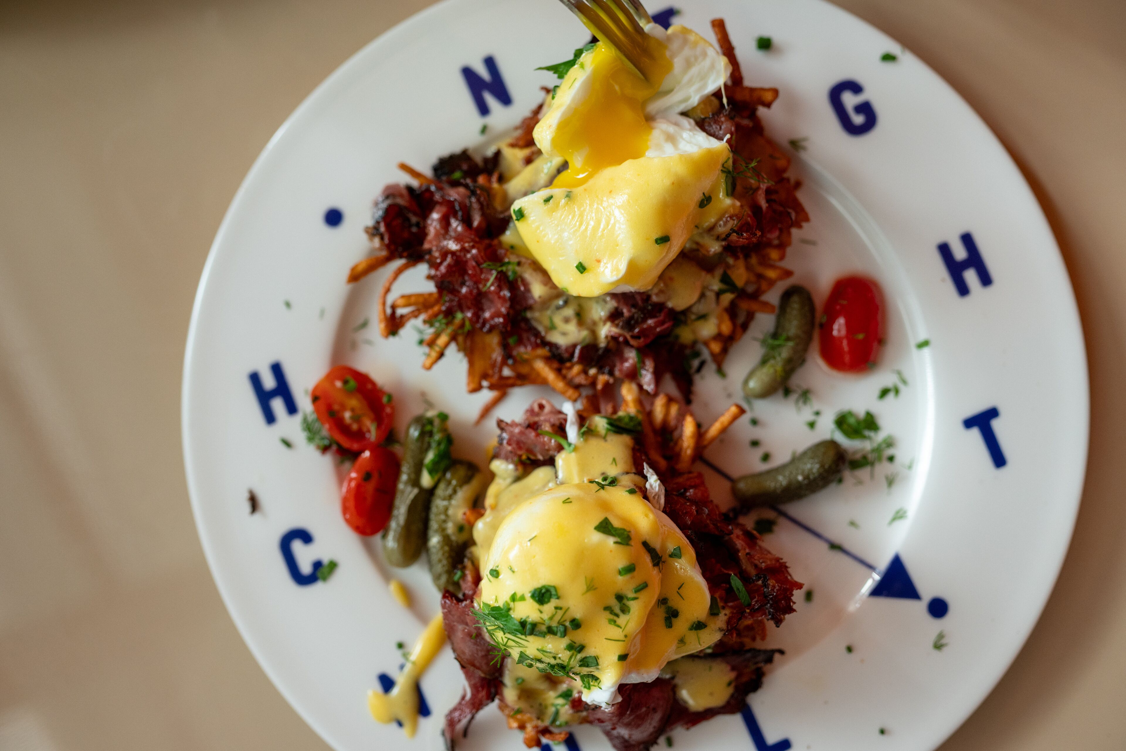 A plate of food with poached eggs, vegetables, and a garnish.