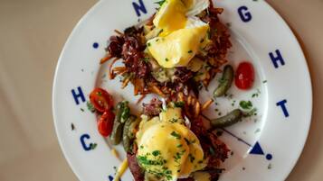 A plate of food with poached eggs, vegetables, and a garnish.