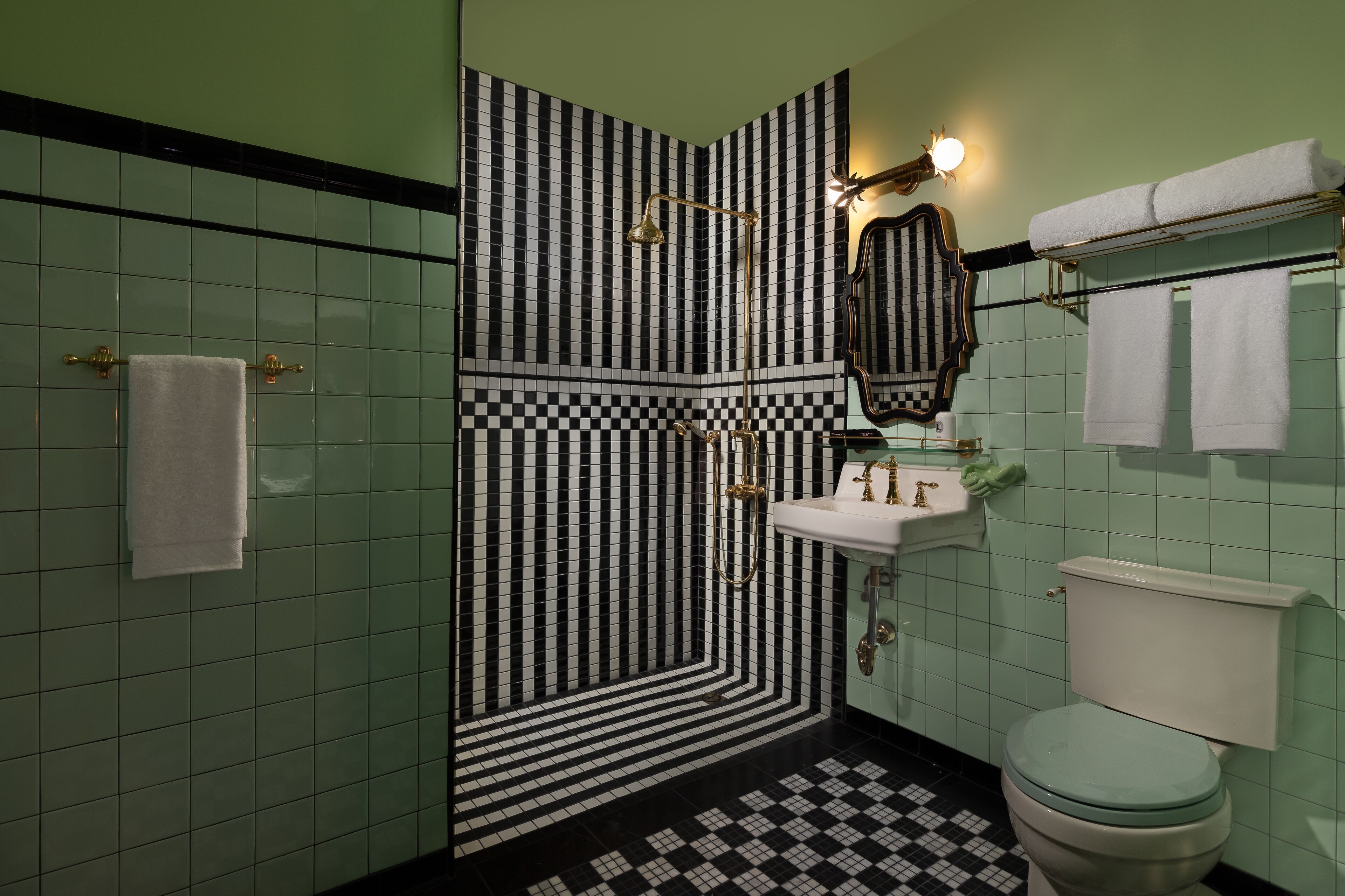 A bathroom with a checkered floor pattern, a sink with a mirror above it, and a toilet.