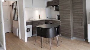 Een moderne keuken met een eettafel, inbouwapparatuur en een grote kast.