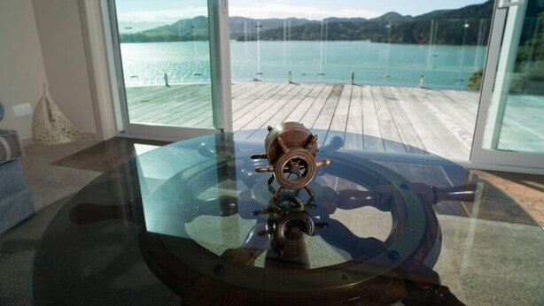 Una habitación con un ventanal que da a un muelle de madera y un lago.