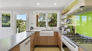 Una cocina moderna con una isla grande, horno empotrado y vistas a zonas verdes.