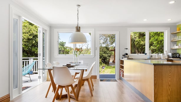 Una cocina moderna con comedor, ventanas amplias y vistas al exterior.