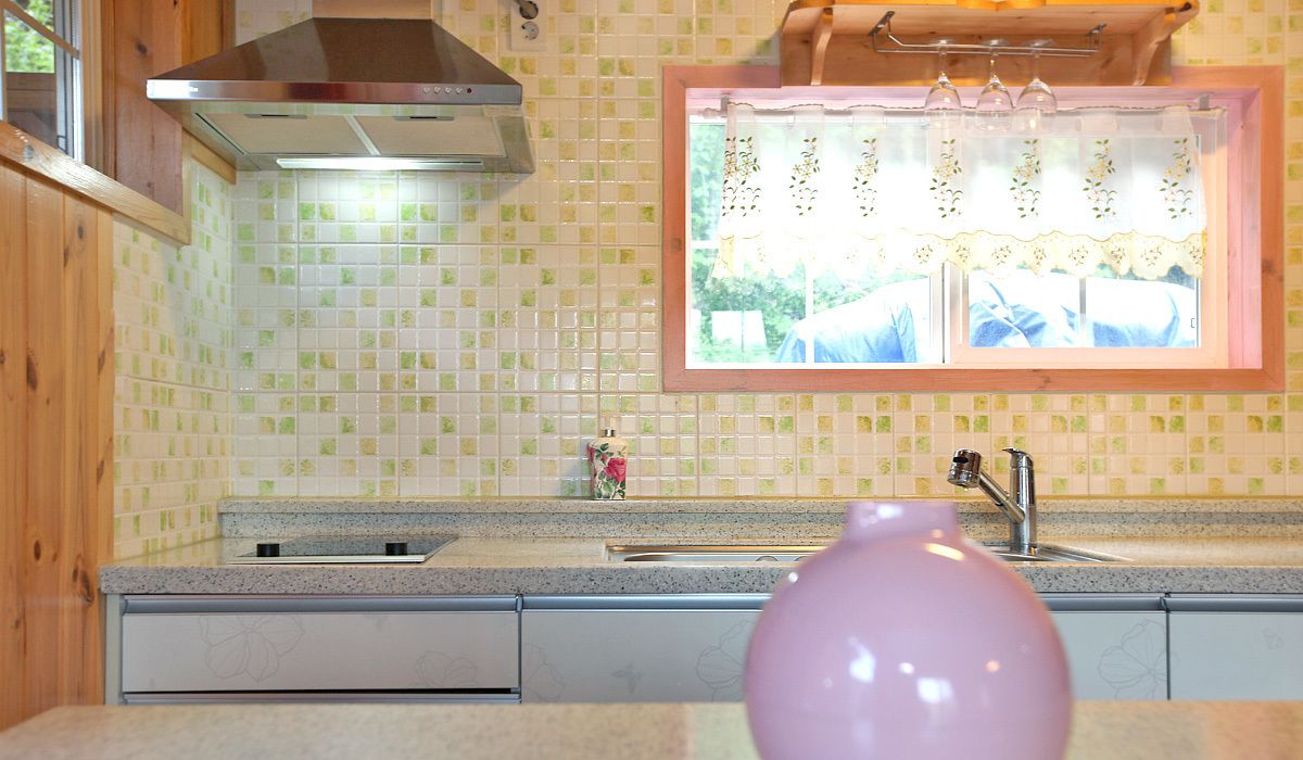 A kitchen with a window, a sink, and a stove.