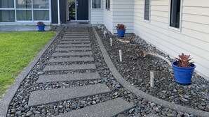 A pathway leading to a modern building with a grey exterior and white siding. - CooksEstuaryEscape-Waterfront at your doorstep (Price enquire for small groups) (Cooks Beach)