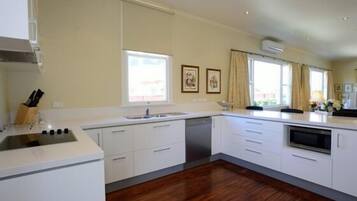 A modern kitchen with white cabinetry, a built-in oven, and a dishwasher.