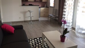A modern living room with a sofa, a coffee table, and a dining area with a chair and a table.