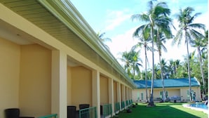 A hotel with a covered outdoor seating area, a pool, and palm trees. - Cococabana Panglao (Panglao)