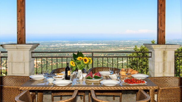 A table set for a meal with a view of a distant landscape.