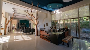 A spacious lobby with a reception desk, seating area, and large windows offering views of the outdoors. - TopTai B&B (Hengchun)