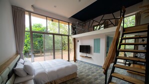 A bedroom with a large bed, a TV, and a wooden staircase. - TopTai B&B (Hengchun)