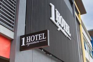 A hotel sign with the name '1 HOTEL signature' on a building facade.