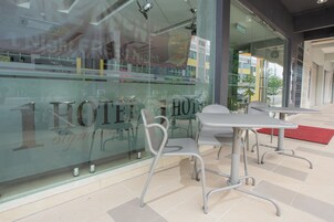 A hotel sign with the name "HOTEL" and "Signature" visible through a glass window.