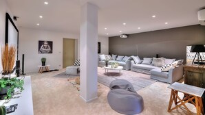 A modern living room with a grey sofa set, a coffee table, and a large pillar.