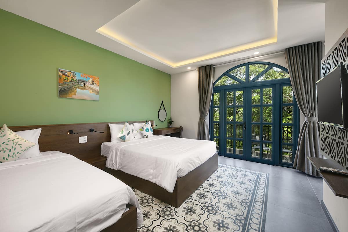 A hotel room with two beds, a large window with a view, a painting on the wall, and a patterned floor.