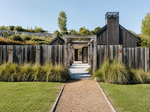 A pathway leading to a building with a wooden fence and a gravel path.