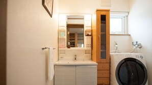 A compact bathroom with a sink, mirror, cabinet, and a front-loading washing machine. - Hakuba Syunrokuan (Hakuba)