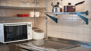 A kitchen with a microwave, a rice cooker, and shelves with cups and a pot. - Hakuba Syunrokuan (Hakuba)
