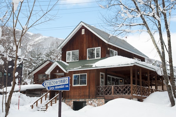 A wooden cabin with a porch and a sign indicating it is located at Goryu Minamidori Ave.