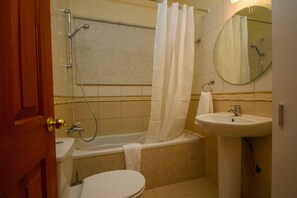 A bathroom with a bathtub, toilet, sink, and a mirror. - Erigone Cottage - Beautiful Ambiance (Vasa)