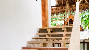A wooden staircase leading to a covered area with a thatched roof. - Higala Hostel Siargao (General Luna)