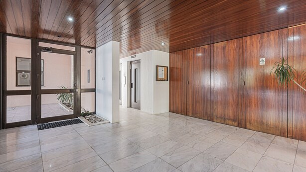 Ein modernes Interieur mit Holzboden, Fliesenboden und einer Holzwand.