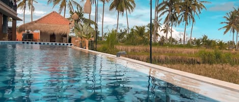 Una piscina al aire libre, sillones reclinables de piscina