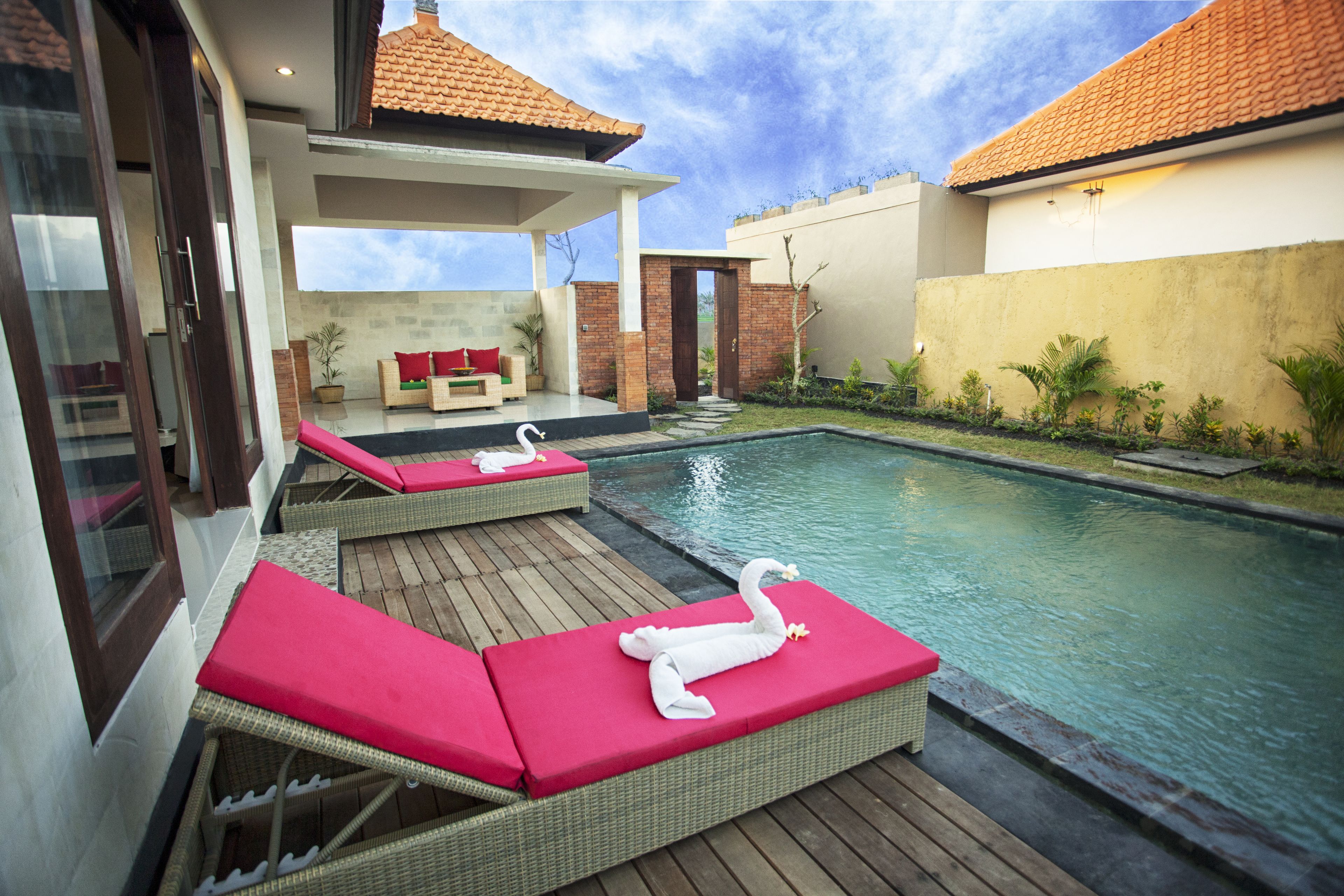 A pool area with lounge chairs and a swan decoration.