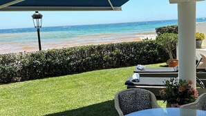 A patio with wicker furniture, a glass table, and a view of the beach. - BEACHFRONT , Central,  quiet,  parking,  pool (Marbella)