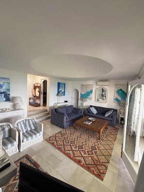 A living room with two sofas, a coffee table, and a patterned rug.