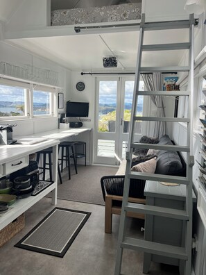 Cocina pequeña con vistas, una escalera y una cama litera.